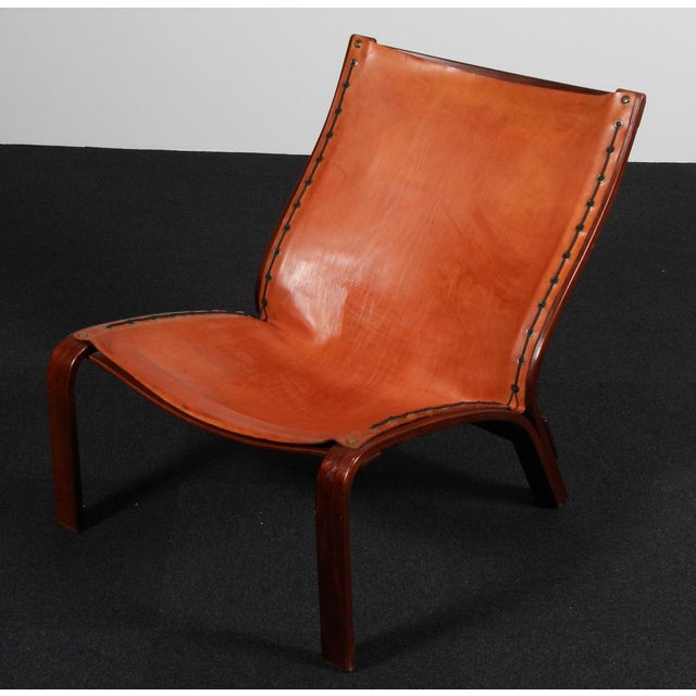 Danish cabinetmaker lounge chair in bended stained beech veener. Seat and back in patinated butt hide leather. Denmark 1970s