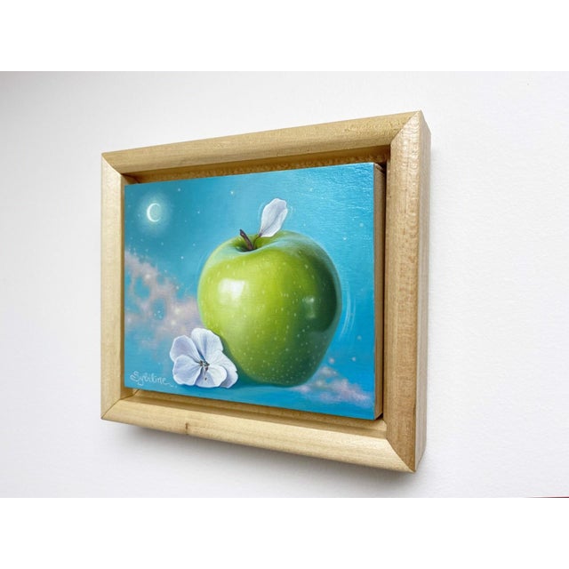This oil painting features a luminous green apple resting beside delicate white blossoms, set against a tranquil turquoise...