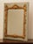 A French painted and carved giltwood mirror from the early 19th century, with cartouche, flowers and foliage motifs....