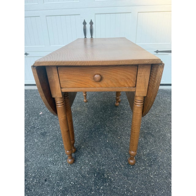 Antique vintage oak gate leg dining table with drawer. This piece is most likely From the 1920’s or 30’s. The table gate...