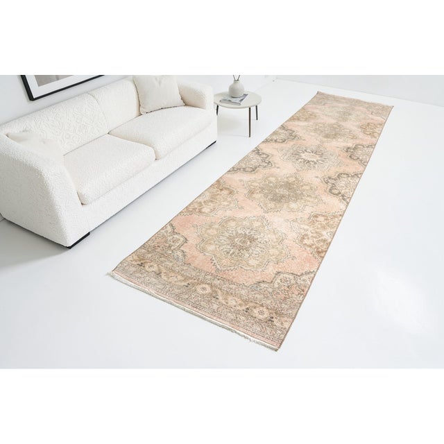 This is a vintage Turkish Oushak rug from the Mid 20th Century. The piece was hand-knotted.