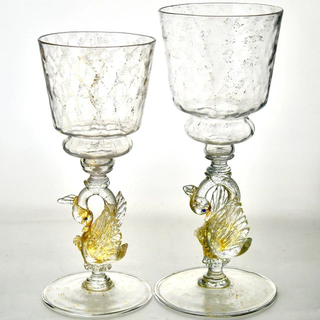 An exquisite set of entirely hand blown Venetian goblets, having a swan shape stem and embellished with shimmering 24...