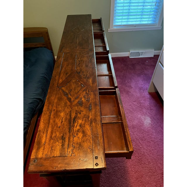 An antiqued wood console table, with four frieze drawers and two further tiers between square tapering supports. Need to...