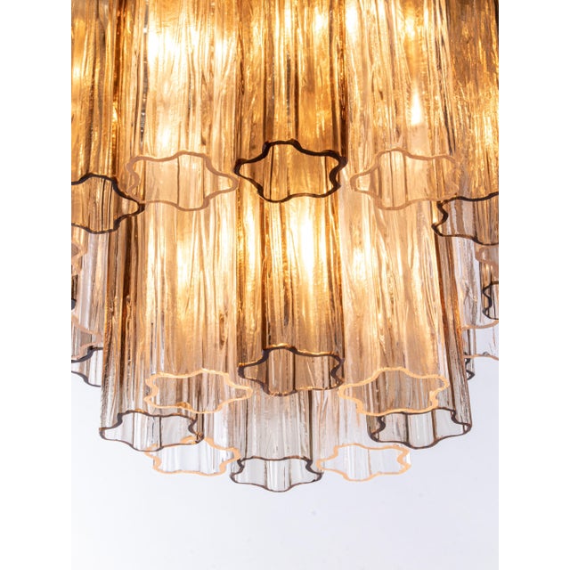 Elegant flush mount ceiling light with 24 clear and amber venini "tronchi" murano glasses on a golden brass frame....