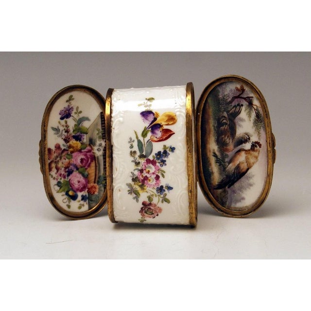 Meissen gorgeous dual lidded rococo box with multicolored paintings and decorations of relief type. The box is edged by...
