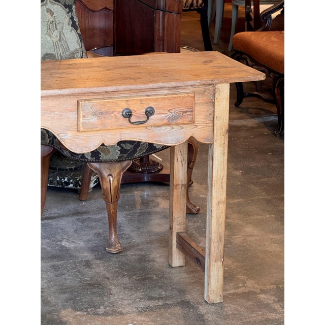 A 19th century pine console with two drawers and a nicely scalloped apron centered by a chip-carved daisy wheel medallion....