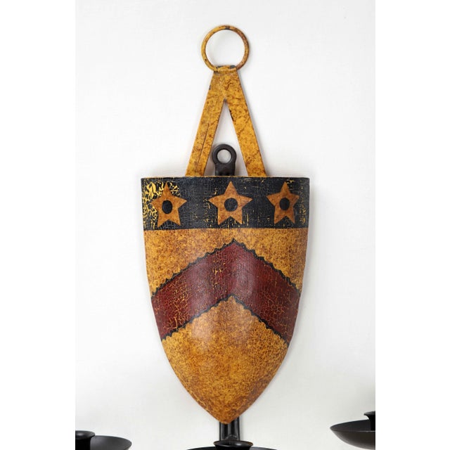 This vintage shield emblem candelabra sconce catches the eye with a red arrow and 3 stars design on a background of rustic...