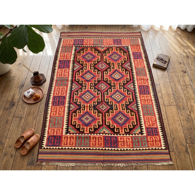 A handwoven Maimana kilim from northern Afghanistan, worked in brick red, chocolate brown, apricot, teal and ivory....