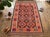 A handwoven Maimana kilim from northern Afghanistan, worked in brick red, chocolate brown, apricot, teal and ivory....
