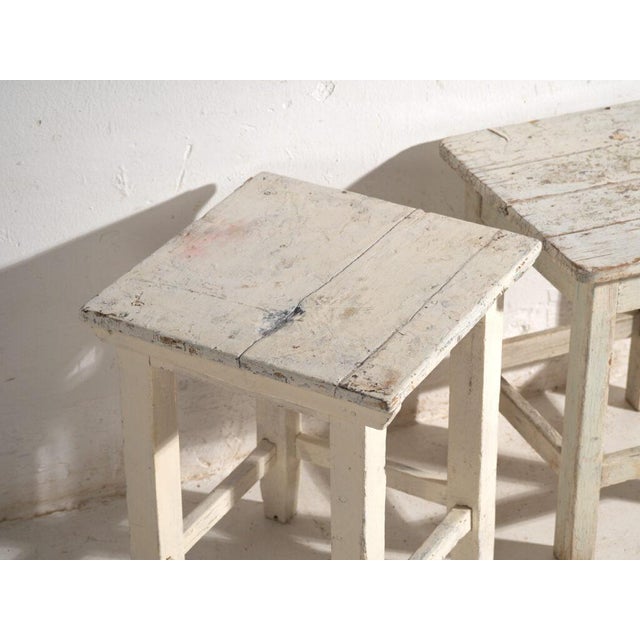 A pair of antique bedside tables in pine wood, with a square top and four tapered legs tied by box stretchers. They...