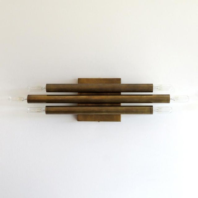 Great aged brass geometric wall light by Gallery L7, manufactured and hand finished in Los Angeles, with three brass...