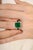 This statement ring features 6.53 Carat of vivid emerald cut emerald at the center, secured in a four prong 14k yellow...