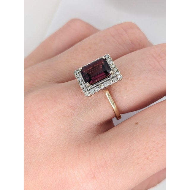 This beautiful ring features a 2.8 carat emerald cut raspberry garnet gemstone with a halo of natural earth mined diamonds...