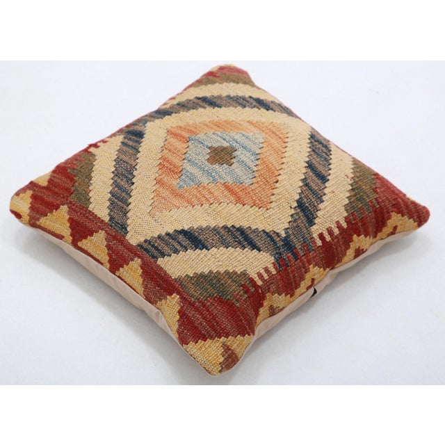 A one-of-a-kind handwoven Afghan wool kilim accent pillow featuring concentric diamond medallion. Cut and sewn by hand...