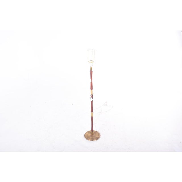 Floor lamp in wood and brass, produced in Denmark. European Plug (up to 250V).The wiring of this item may be original and...