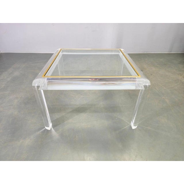 Italian modernist coffee table produced in the 1980s. The table features a sculptural clear acrylic frame with rounded...