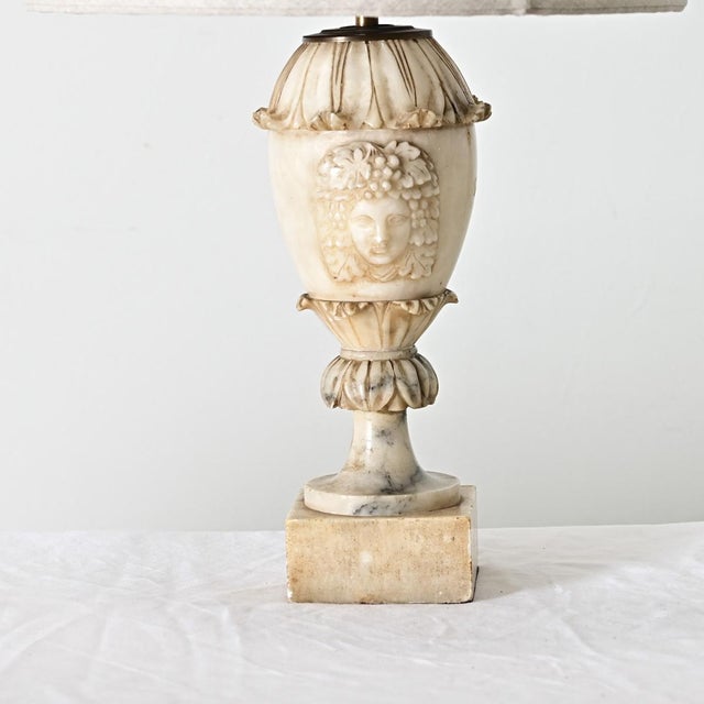 A French Empire style carved marble table lamp featuring a visage of Bacchus, the Roman god of wine, to grace the urn of...