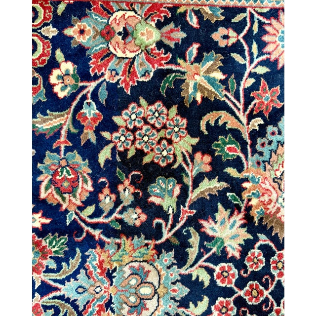 This striking handmade wool rug captures timeless elegance with its intricate floral motifs and rich, saturated palette....