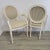 A refined pair of Louis XVI–style armchairs by Ethan Allen, featuring oval backs, fluted legs, and delicately carved...