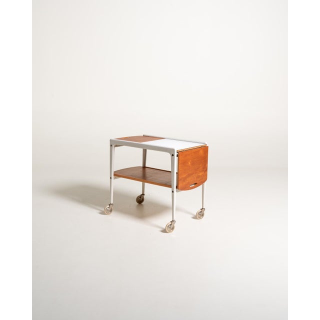 "Thea" serving trolley by Yngve Ekström, Sweden, 1950s/1960s: white painted frame, teak and laminate shelves, foldable...