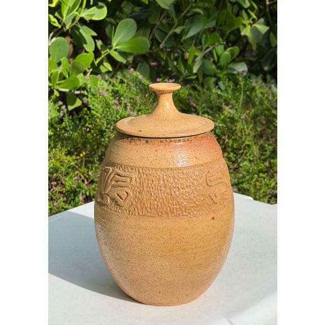 Striking vintage handcrafted studio pottery vessel with a rounded, organic form and fitted lid topped by a sculptural...