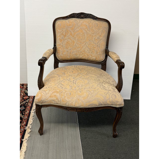 Design Plus Gallery presents an Ornate Carved Wood Armchair. The shaped wood frame displays elaborate carved detailing...