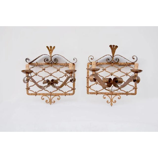 Pair of gilded wrought iron wall sconces, 1950s, Made in Italy. Wall sconces in the style of Pierluigi Colli made of...