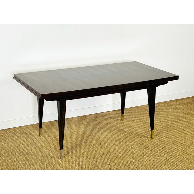 A sublime art deco extendable table crafted from varnished macassar ebony, featuring a magnificent vertical grain veneer...