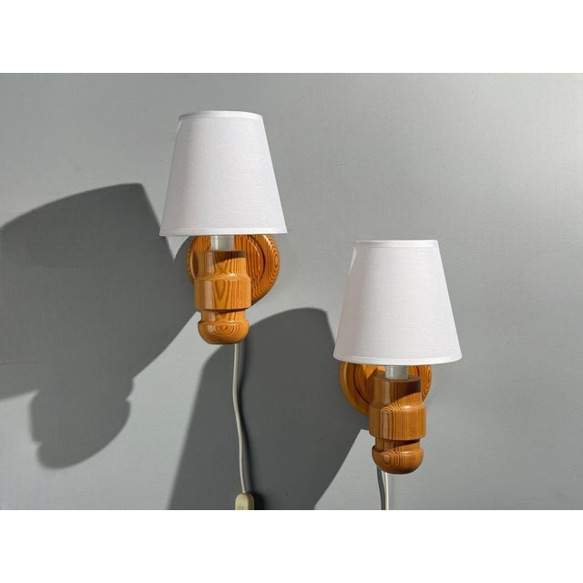Solbackens Svarveri, Swedish Mid-Century Modern, Wall Lights, Pine, Fabric, Sweden, 1960s Pair of carved and stained pine...