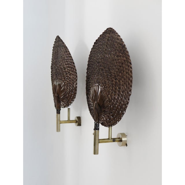Pair of wall sconces, in the style of Ingo Maurer, with brass structure and fan-shaped diffuser in natural material, made...