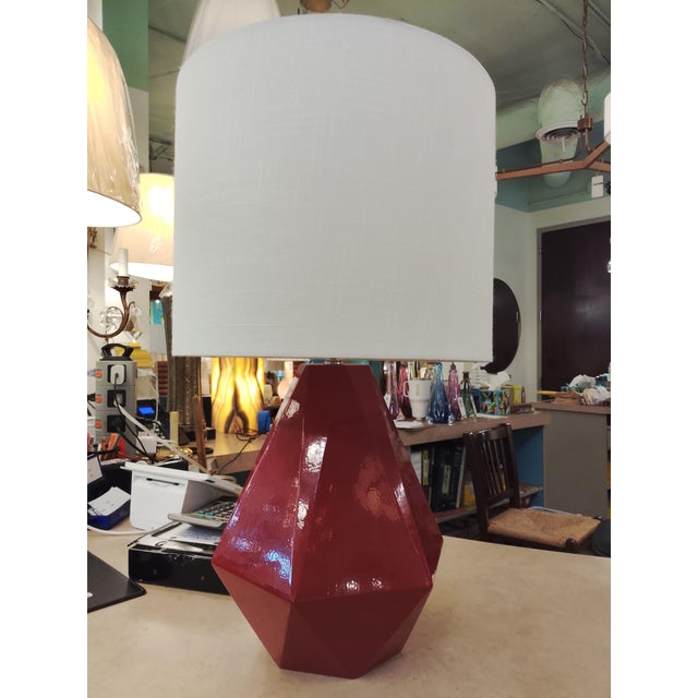 14" x 14" x 33". Red modern lamp with linen drum shade. By Robert Abbey.