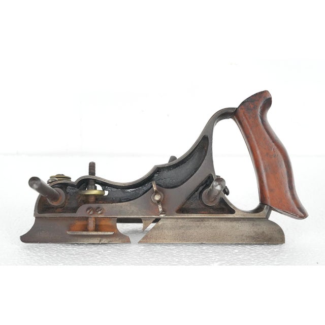 Antique steel plow plane made by Sieglet Company. It features a wooden handle, depth adjustment mechanism, and sliding...