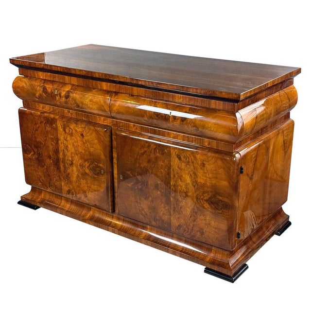 Art Deco sideboard featuring a striking walnut veneer with beautifully pronounced grain. The sculptural form is enhanced...