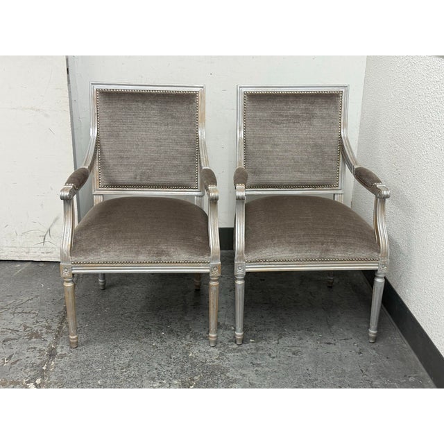 Design Plus Gallery presents a Pair of Louis XVI–Style Square-Back Armchairs. The chairs are showcasing a tailored...