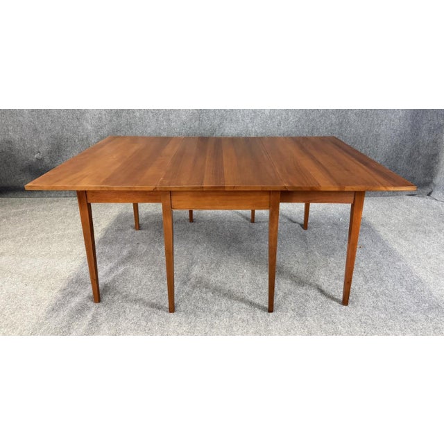 This vintage Craftique dining table is crafted from solid mahogany and features a classic drop-leaf design that allows the...