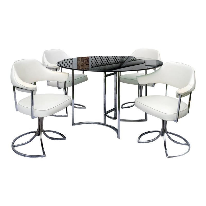 A round table with four white chairs