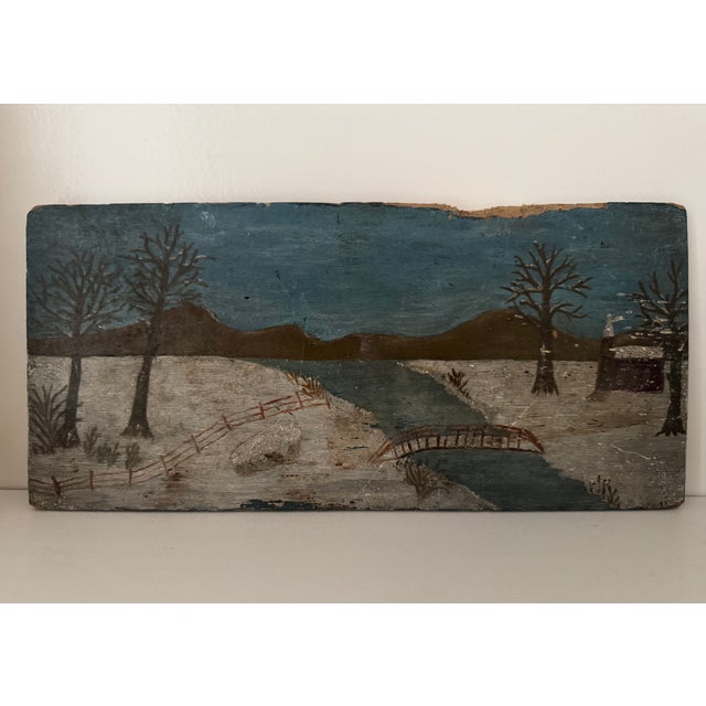 Charming folk art winter landscape, painted on a wooden board, circa 1930s. The primitive, hand-painted style and muted...