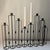 Black Brutalist style expandable sculptural multi-holder tapered candelabra in a stepped silhouette. Each metal leg has a...