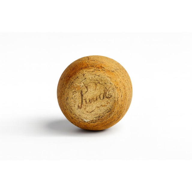 A tall vase with a slender vertical profile and textured finish. The surface reveals subtle ridging and variation, lending...