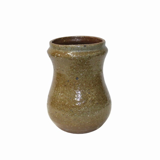 This is a handmade ceramic small jar vase with a rough surface and shape. It has a vintage brownish tan gray tone color...