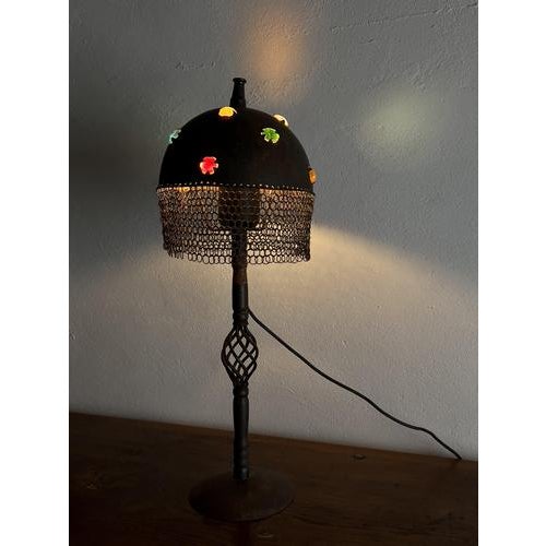 An unusual and striking sculptural lamp, handcrafted from forged iron in the shape of a medieval-style helmet. The dome is...