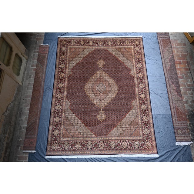 This stunning Persian-inspired hand-knotted rug features a timeless medallion design set against a rich burgundy...