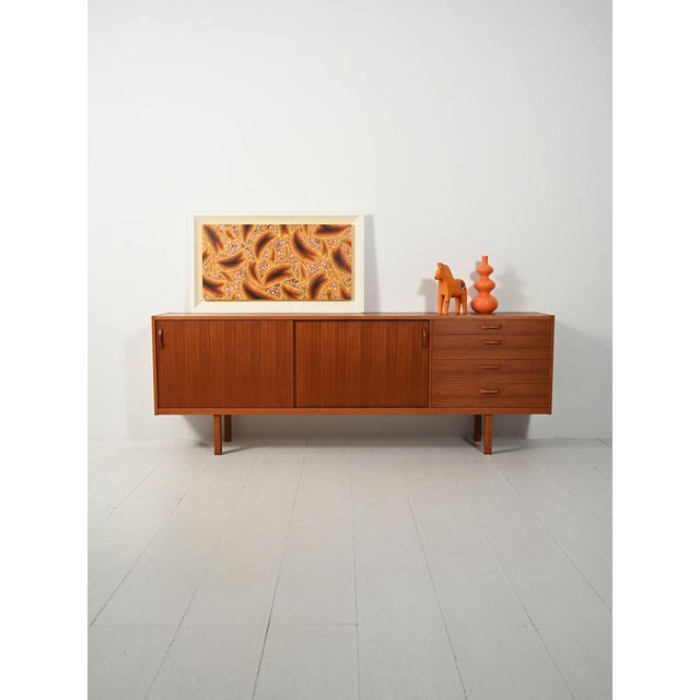 Ulferts teak sideboard, linear design on slender legs: sliding doors, drawers, and cutlery drawer; original brand. Ulferts...