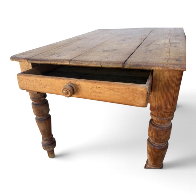 An English Pine Farmhouse Table. Single drawer to the end with a wooden knob. Solid plank top. Turned legs. Great old patina.