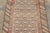 Handwoven in wool, circa 1900–1920, this antique 2x12 Kurdish runner rug features a richly patterned field with repeating...