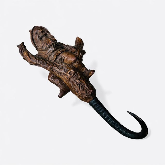 A 1900s Black Forest carved wood gnome sitting on a tree branch — a charming whip hook with wonderful folk character....