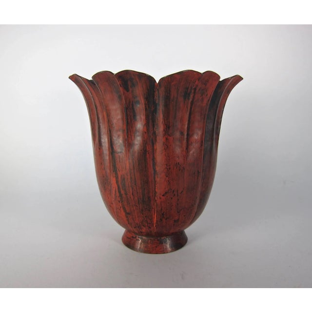 A fluted floriform copper vase with a distinctive red patina and a flaring rim on a small pedestal foot by noted American...