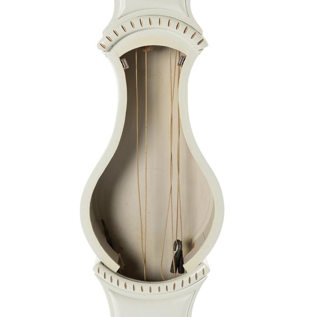 Antique Swedish Mora clock from the 19th Century with later painting. Hand carved detailing to crown and white painted...