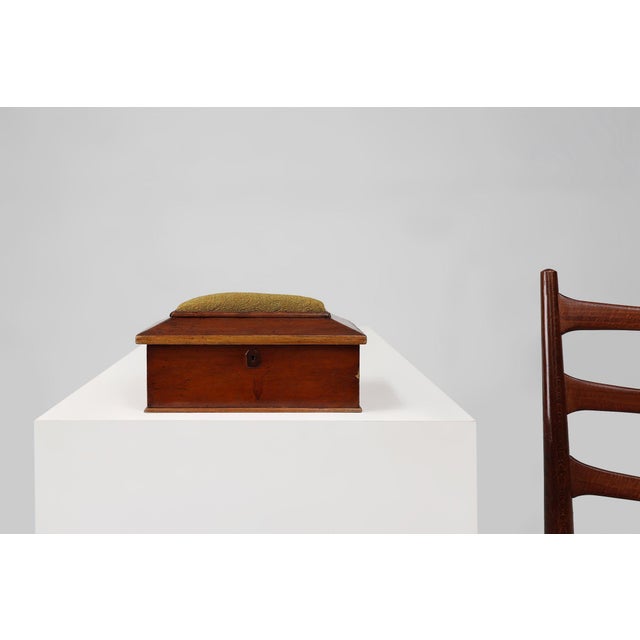 A charming French sewing box from the early 20th century, crafted in polished wood with a textured fabric cushion inset on...