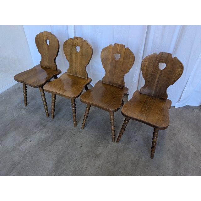 Set of 4 vintage wooden dining chairs in Tyrolean style. The chairs feature solid wooden construction with bobbin-turned...